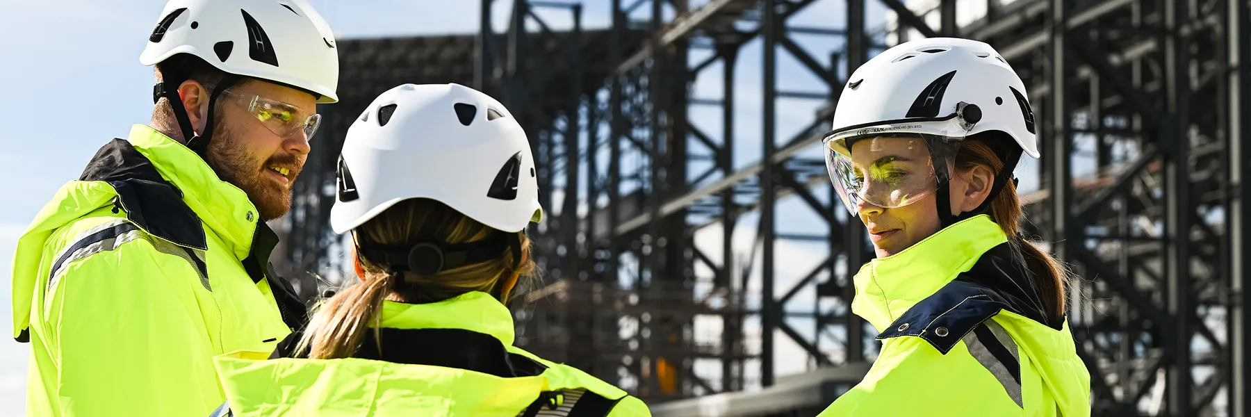 Three Stegra Electricians in safety vests and helmets standing together