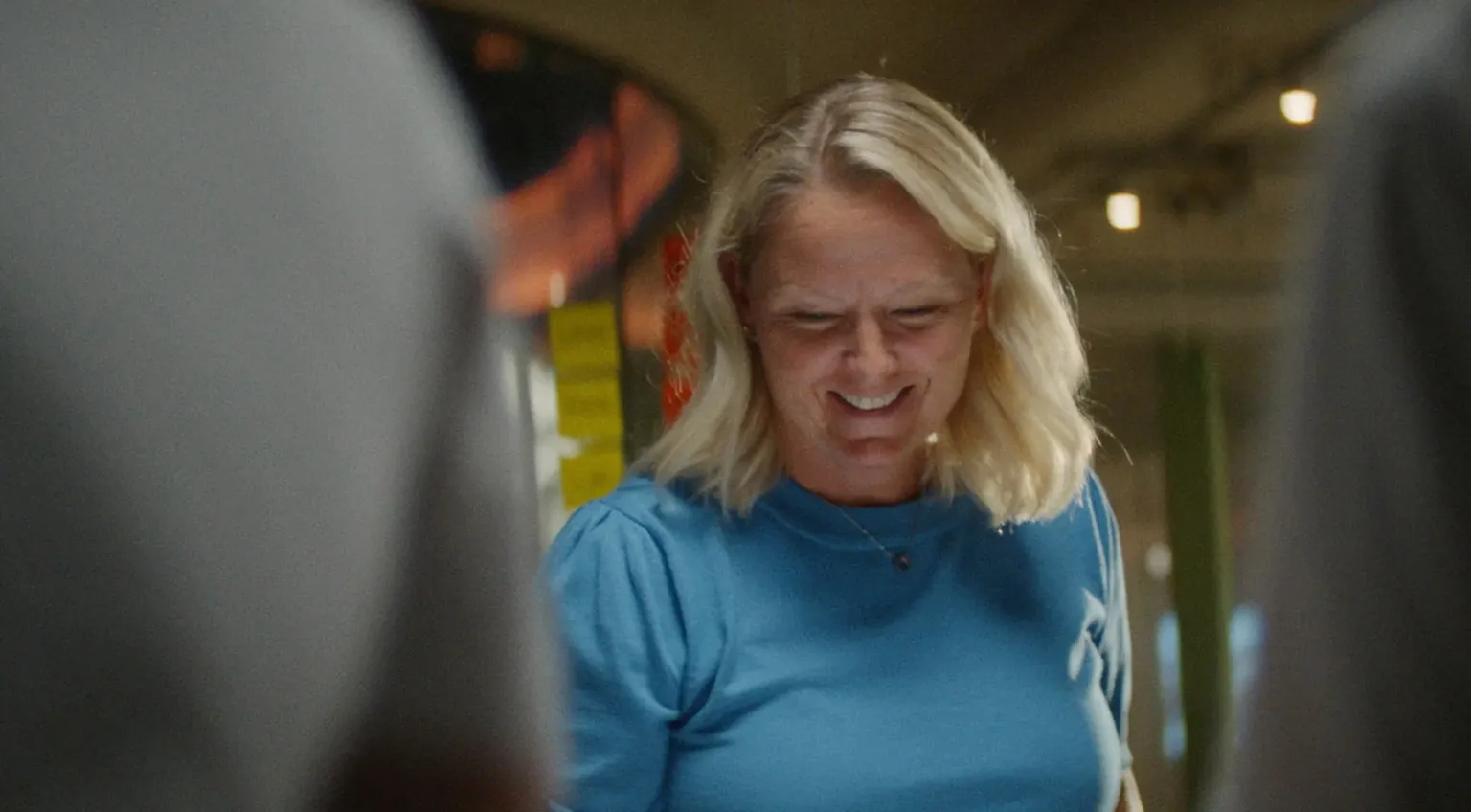 A woman in blue smiles as she works in a team