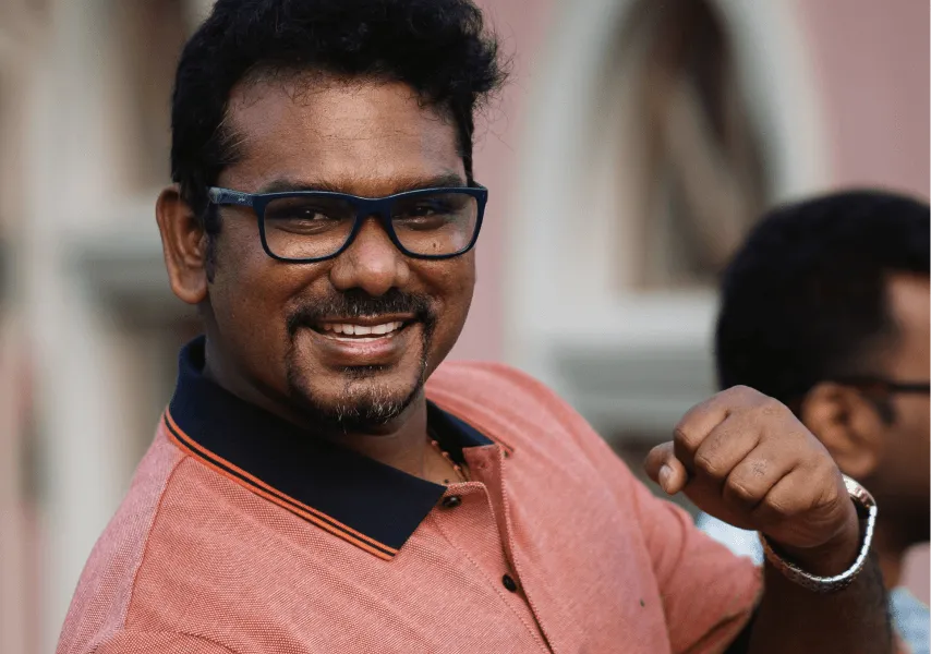 A male employee smiles and looks to camera