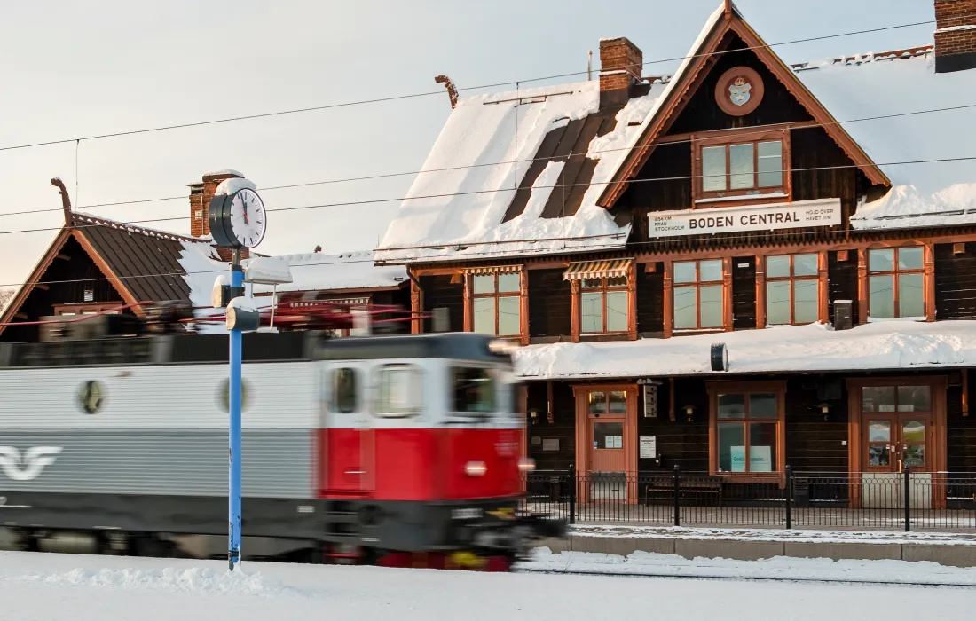 A train passes by a snowy station building