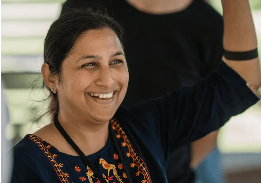 A female employee raises her hand and smiles