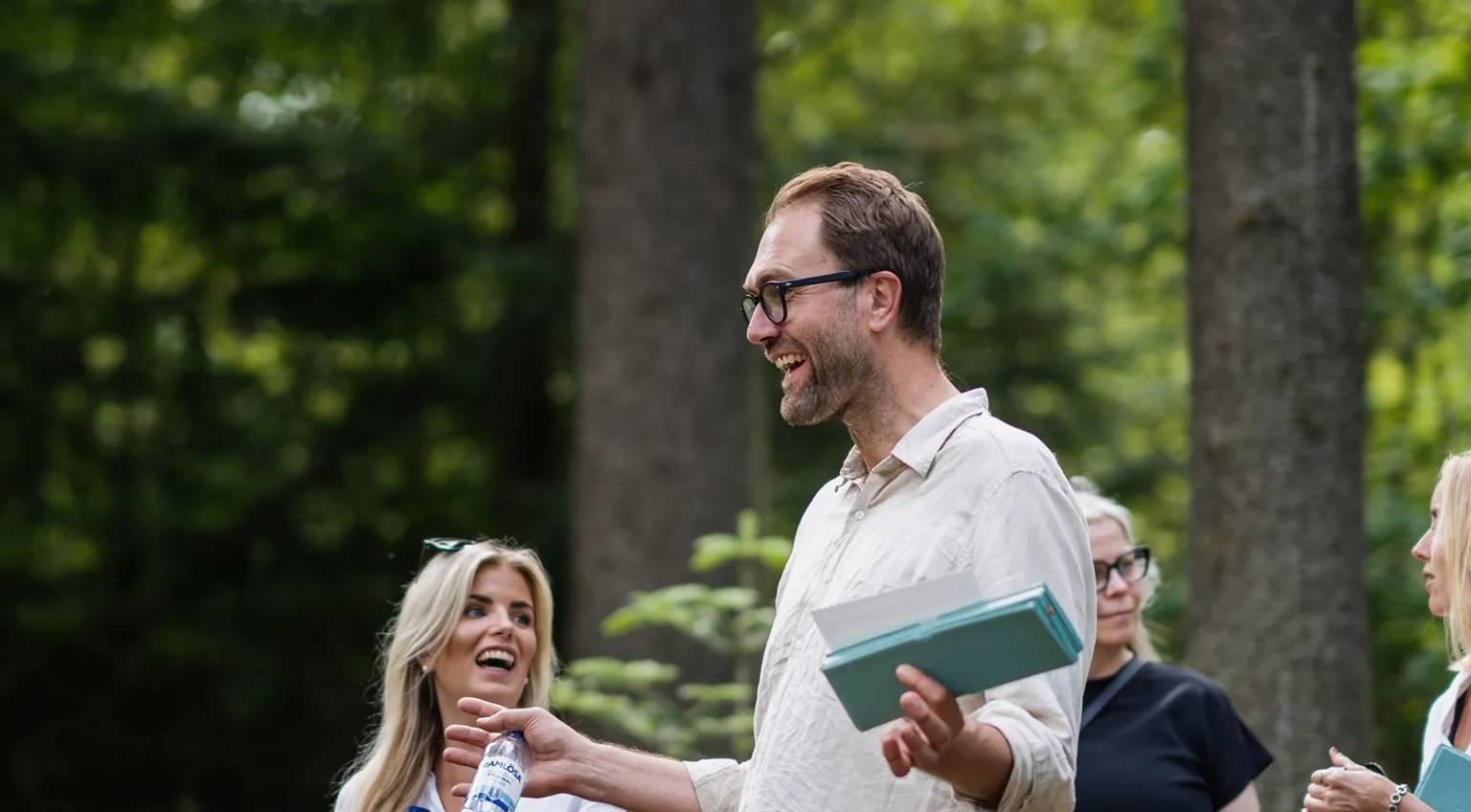 A group of people outdoors being addressed by a man